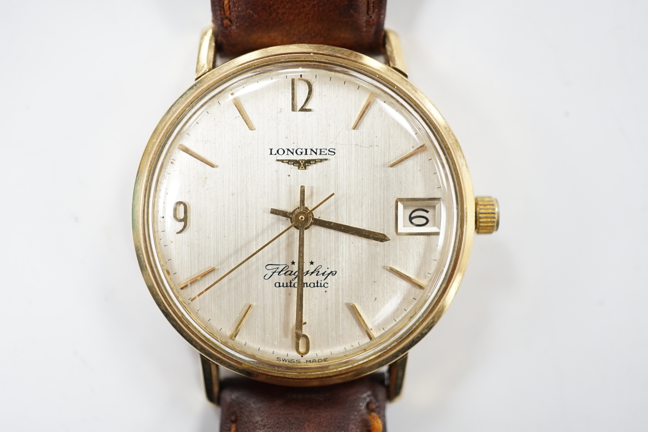 A gentleman's 9ct gold Longines Flagship automatic wrist watch, with baton numerals and date aperture, on associated leather strap.